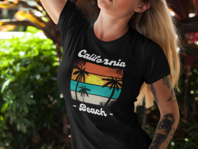 Vintage California beach T-shirt featuring a retro sunset and palm tree design on a classic coastal background.